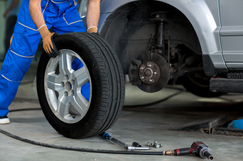 Mmechanic changing wheel of a modern car